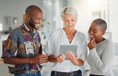 Buy stock photo Three happy businesspeople using a digital tablet together at work. Mature caucasian businesswoman talking and showing her african american colleagues an idea of a digital tablet in an office