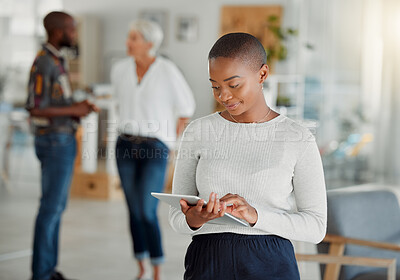 Young happy african american businesswoman holding and using a digital tablet at work. Black female businessperson working on a digital tablet at work. Black woman using social media and browsing online