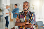 Portrait of a happy African american businessman standing with his arms crossed at work. One confident male manager standing in an office at work. One content expert business professional at work