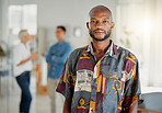 Portrait of a young african american businessman standing in an office at work. Male businessperson standing in an office at work. Focused business professional at work