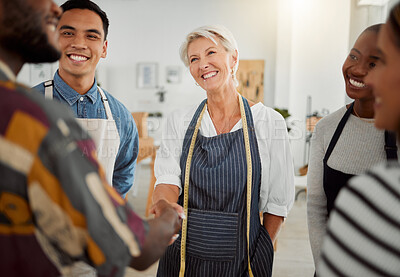 Buy stock photo Group of happy diverse creative designers having a meeting while standing together at work. Coworkers greeting and shaking hands in an office. Male and female coworkers discussing a strategy