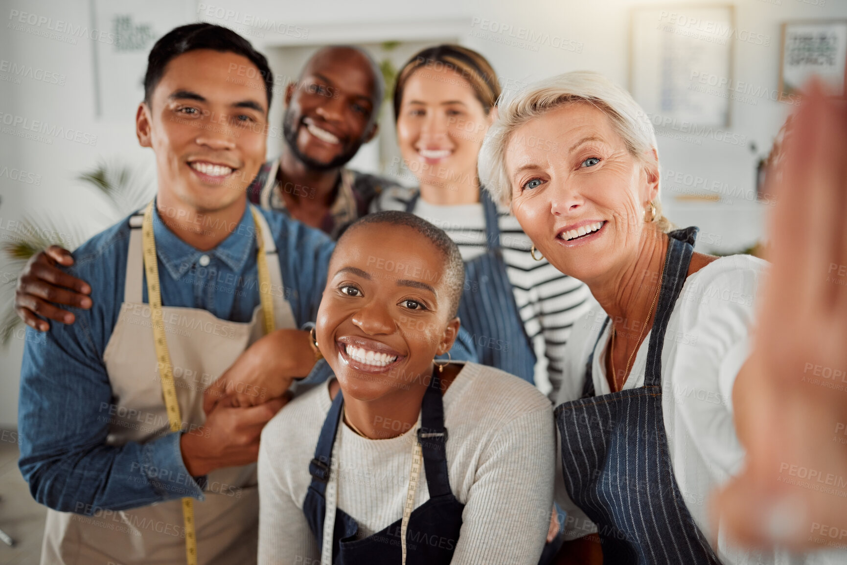 Buy stock photo Portrait of a group of five diverse creative clothing designers taking a selfie together while at work. Mature caucasian female tailor taking a photo with her colleagues working at a boutique