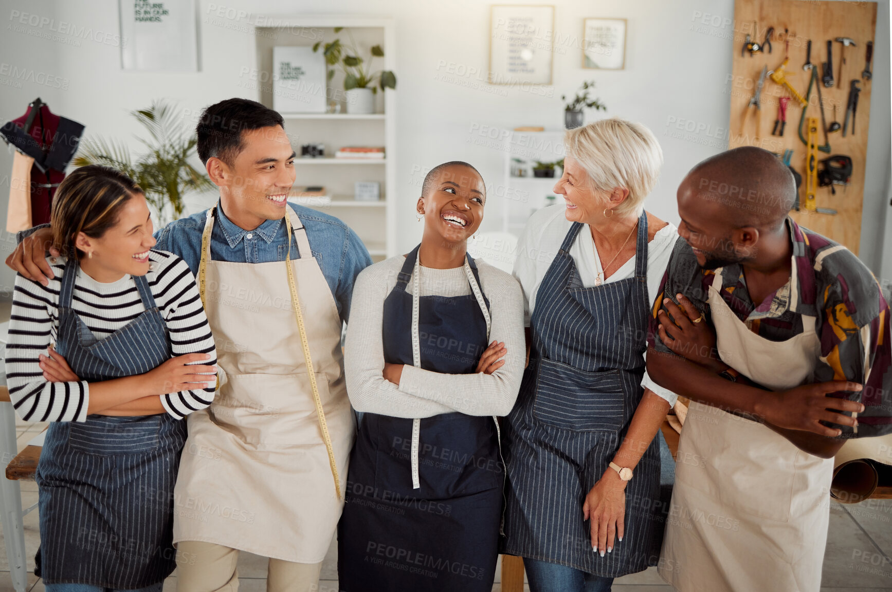 Buy stock photo Group of five cheerful diverse clothing designers standing with their arms crossed in a shop at work. Tailors smiling and laughing while standing together in a boutique
