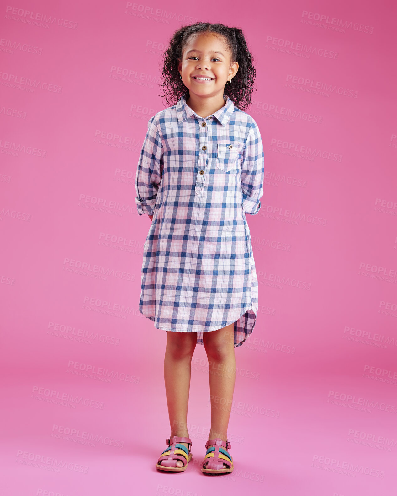 Buy stock photo A portrait of a pretty little mixed race girl with curly hair posing against a pink copyspace background in a studio. A smiling African child wearing casual clothes indoors