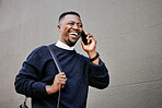 African american male on a phone call with his mobile device outside a building during the day while smiling Young black male talking on a phone while commuting to work