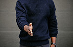 Closeup of an unknown businessman holding his hand out for a handshake in a outside in the city