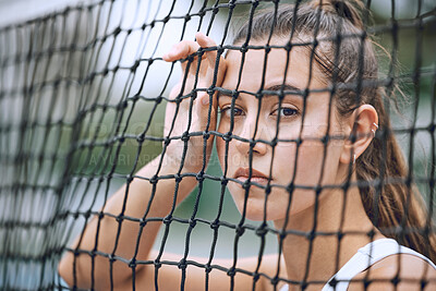 Buy stock photo Close up of a female athlete leaning against a tennis net. Young hispanic tennis player posing on a tennis court