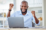 Young happy african american businessman cheering with joy and working on a laptop in an office at work alone. One cheerful male business professional cheering with his fists and using a computer while sitting at a desk