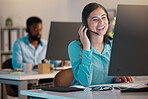One happy young caucasian call centre telemarketing agent talking on a headset while working on a computer in an office. Confident and friendly businesswoman consultant operating a helpdesk for customer service and sales support