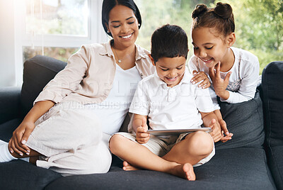 Happy young hispanic family sitting together and using tablet. Curious cute little girl and boy sitting with their mother and learning watching videos online