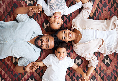 Buy stock photo Portrait of a mixed race family laying on the floor at home. Hispanic family bonding while laying on the ground at home