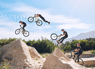Buy stock photo Young man showing his cycling skills while out cycling on a bicycle outside. Adrenaline junkie practicing a dirt jump outdoors. Male wearing a helmet doing extreme sports with a bike. Phases of a jump