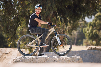Buy stock photo Portrait of a handsome man wearing a helmet and taking a break from cycling on his bicycle outside. Male athlete exercising in a park. Sporty male training on his bike. Keeping his heart healthy