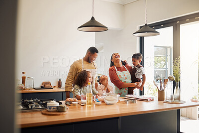 Buy stock photo A happy mixed race family of five relaxing in the kitchen and cooking together. Loving black family being playful while baking together. Young couple bonding with their foster kids at home