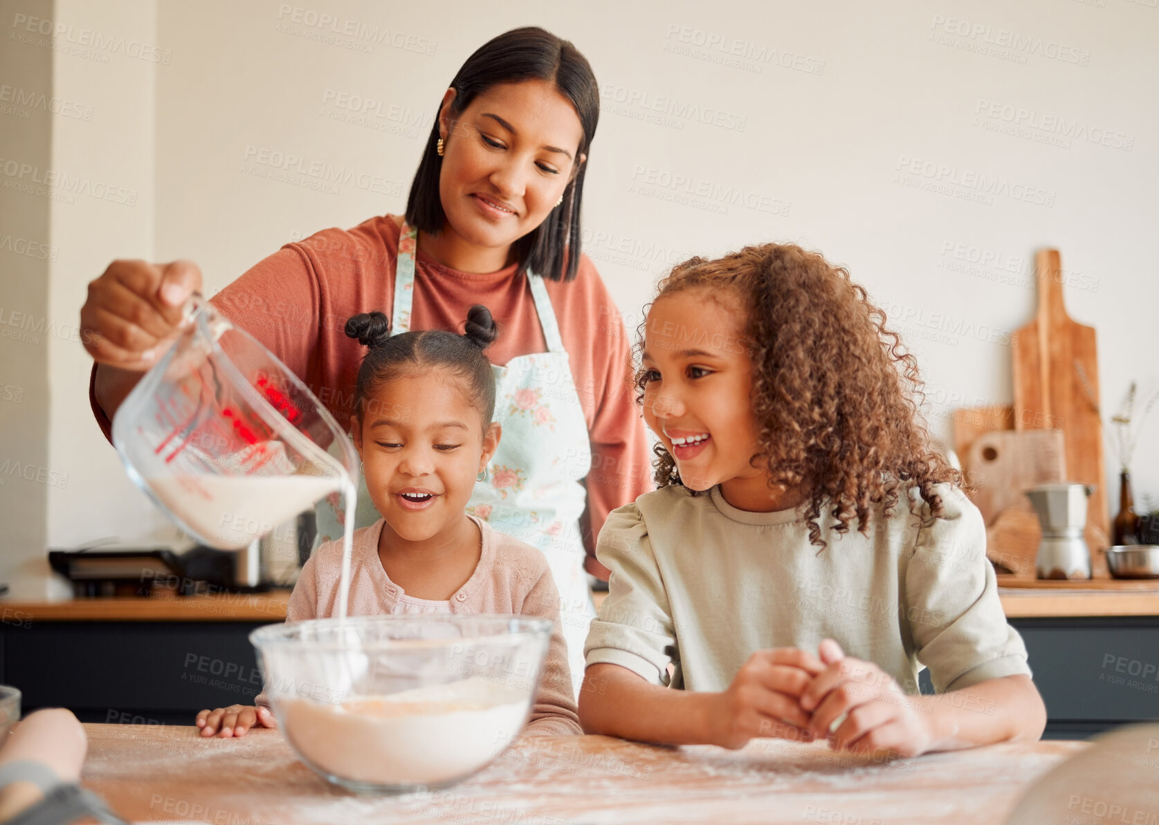 Buy stock photo Females only, happy mixed race family of three cooking in a messy kitchen together. Loving black single parent bonding with her daughters while teaching them domestic skills at home