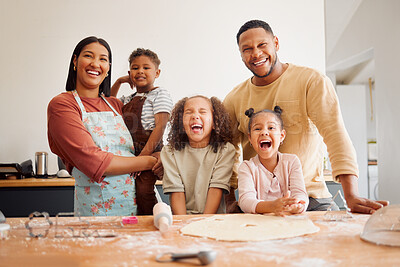 A happy mixed race family of five relaxing and cooking together. Loving black family being playful while baking together. Young couple bonding with their foster kids at home in a messy kitchen