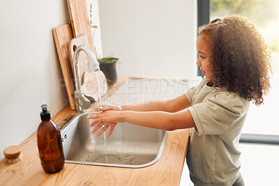 Buy stock photo One mixed race adorable little girl washing her hands in a kitchen sink at home. A happy Hispanic child with healthy daily habits to prevent the spread of germs, bacteria and illness