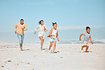 Cheerful young mixed race family running on the beach, Happy mother and father with two children having fun during summer holiday. Playful casual family racing on sandy beach enjoying time together