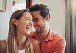 Close up of funny young caucasian couple laughing with their eyes closed and looking happy to be together while spending time at home. Loving smiling boyfriend embracing girlfriend from behind