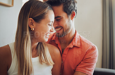 Buy stock photo Close up of funny young caucasian couple touching heads laughing and looking happy to be together while spending time at home. Loving smiling boyfriend embracing girlfriend from behind