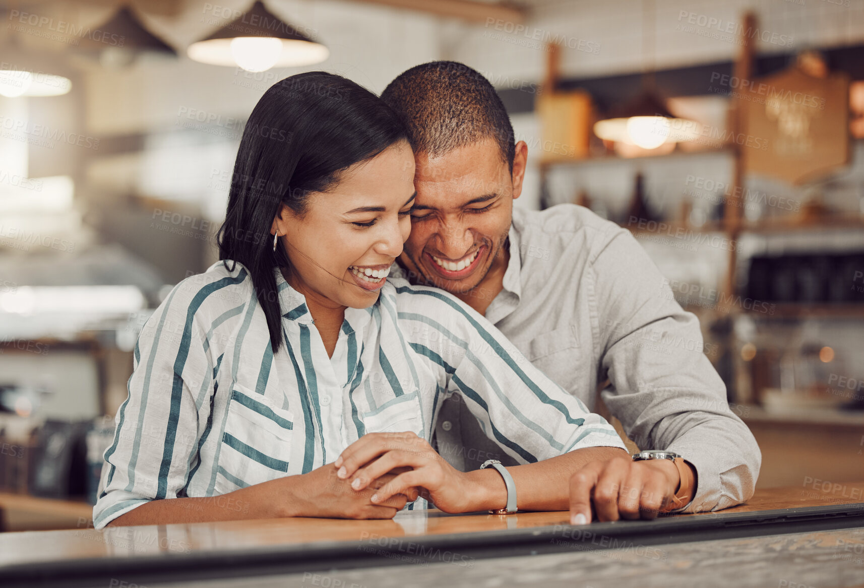 Buy stock photo Loving mixed race couple laughing and enjoying time together on first date. Young woman and man on a coffee date in a cafe