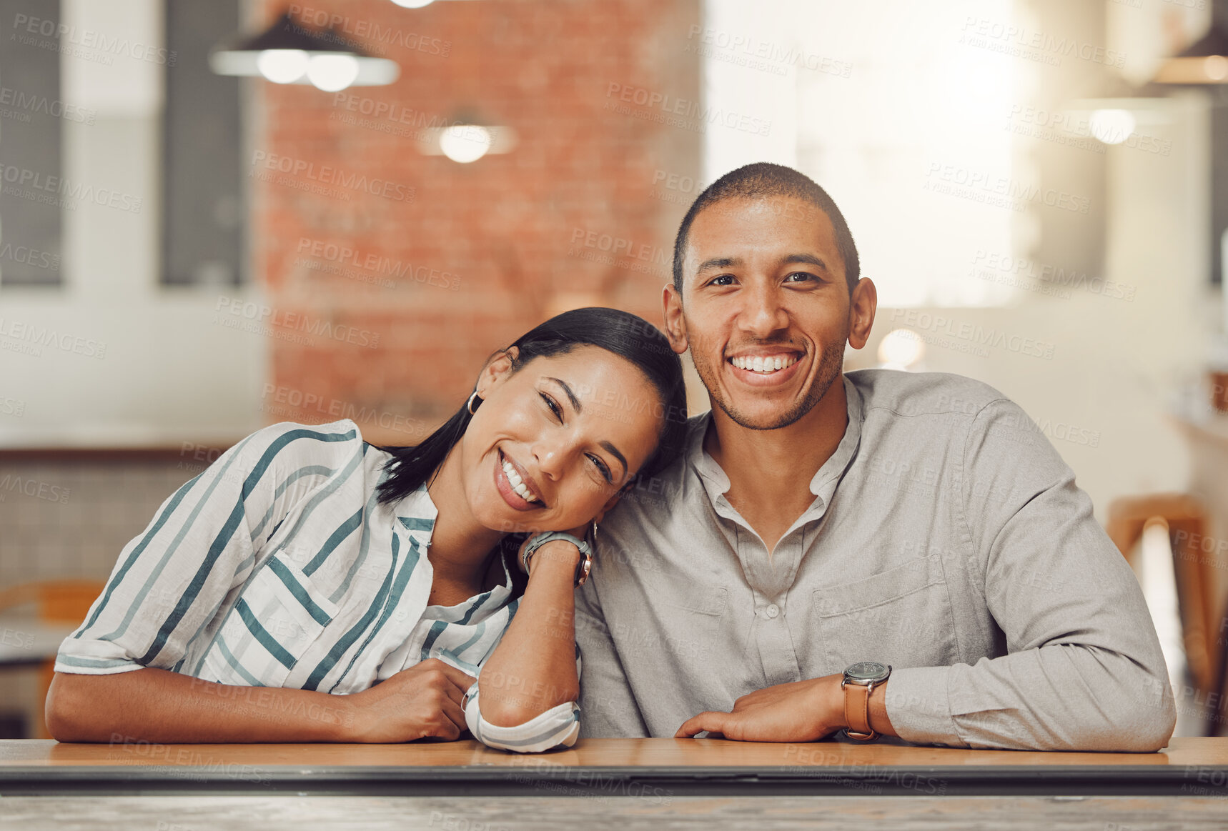 Buy stock photo Portrait of happy loving mixed race couple enjoying time together on first date. Young woman and man on a coffee date in a cafe during the day