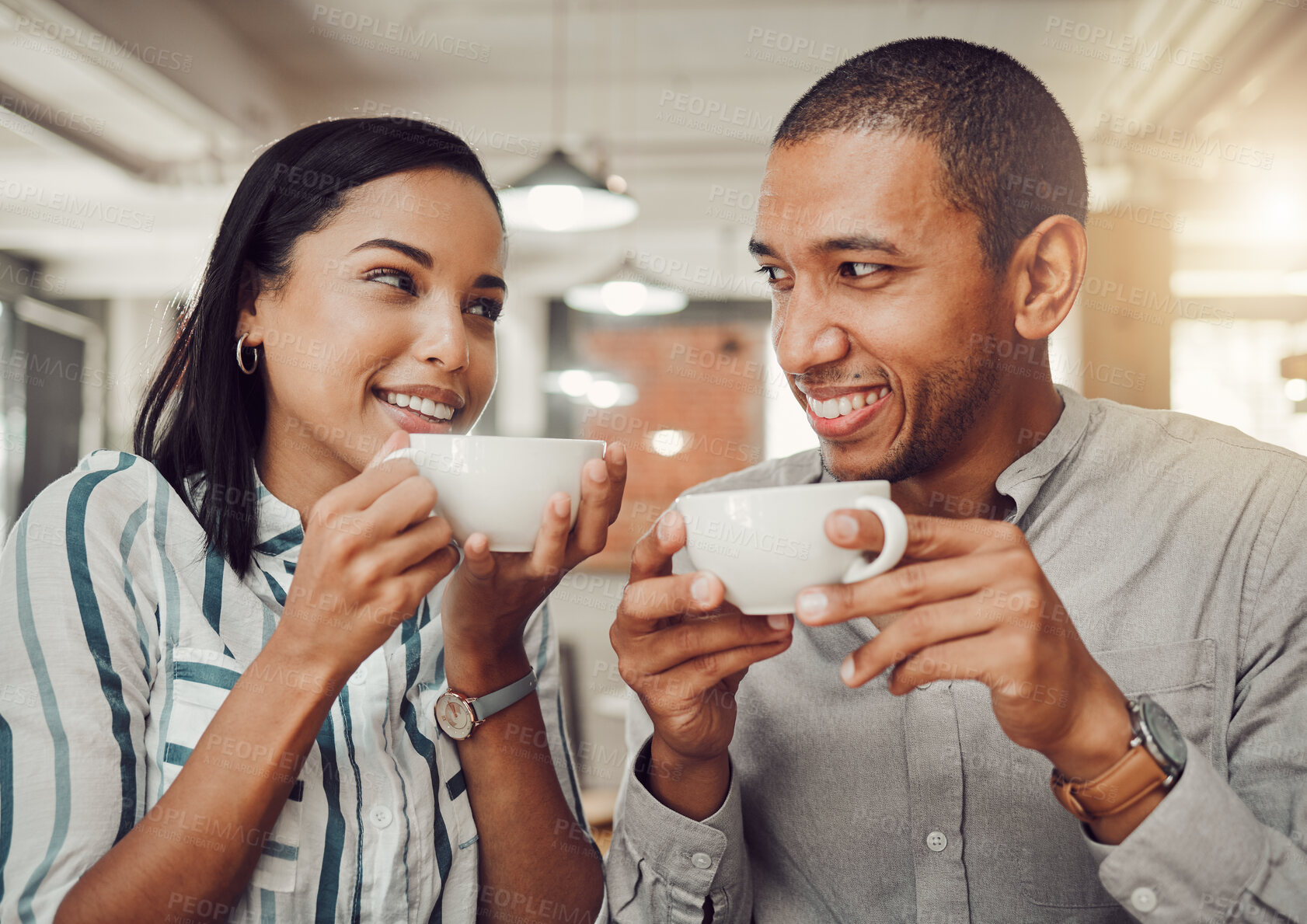 Buy stock photo Loving mixed race couple in love looking at each other while holding cups enjoying coffee in a cafe. Happy young woman and man on their first date in a restaurant