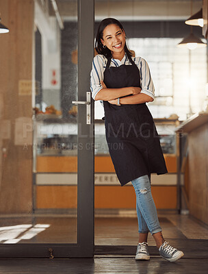 Portrait of confident businesswoman leaning on her business door. Young boss arms crossed in her store entrance. Business assistant standing in her cafe entrance. small business owner in her store