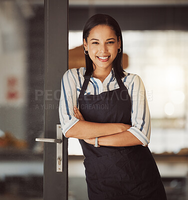Beautiful businesswoman standing in her cafe entrance. Mixed race boss arms crossed in her coffeeshop. Bistro owner standing in her restaurant entrance. Portrait of small business owner in her store