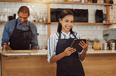 Portrait of a businesswoman ordering stock on her digital tablet. Business partners working together in restaurant kitchen. Entrepreneur using a wireless online device to order stock