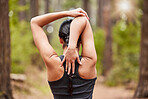 Rear view of mixed race female athlete stretching before a run outside in nature. Exercise is good for your health and wellbeing. Stretching is important to prevent injury
