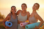 Portrait of yoga women bonding, holding yoga mats in outdoor practice in remote nature. Diverse group of young smiling active friends standing together. Three happy people getting ready to be mindful