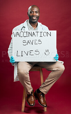 Buy stock photo African american covid doctor holding and showing poster. Full length portrait of smiling black physician isolated against red studio background with copyspace. Man promoting corona vaccine on sign