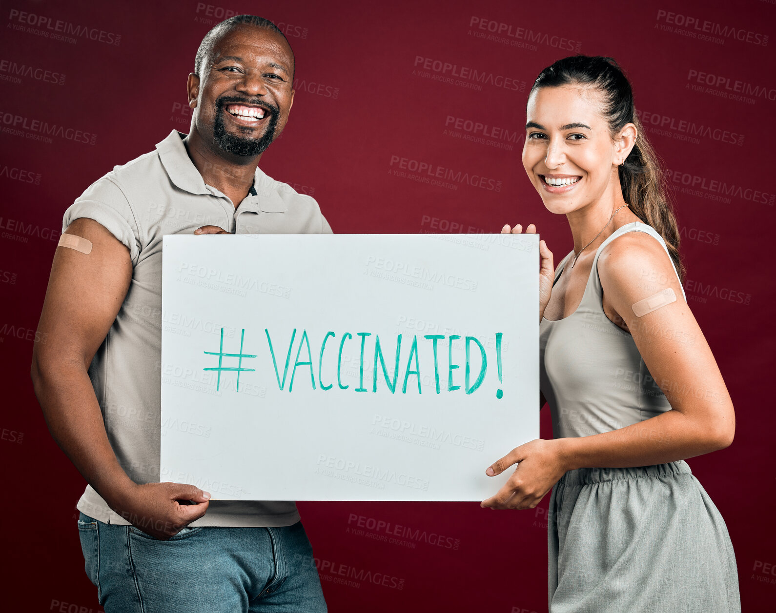 Buy stock photo Covid vaccinated African american man and mixed race woman showing and holding poster. Two people isolated on red studio background with copyspace. Showing plaster on arm and promoting corona vaccine