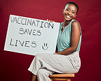African american covid vaccinated woman showing and holding poster. Portrait of smiling black woman isolated against red studio background with copyspace. Model promoting corona vaccine with sign