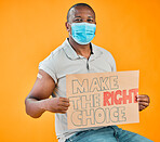 African american covid vaccinated man showing arm plaster, holding poster and wearing surgical face mask. Black model isolated on yellow studio background with copyspace. Corona vaccine promote sign