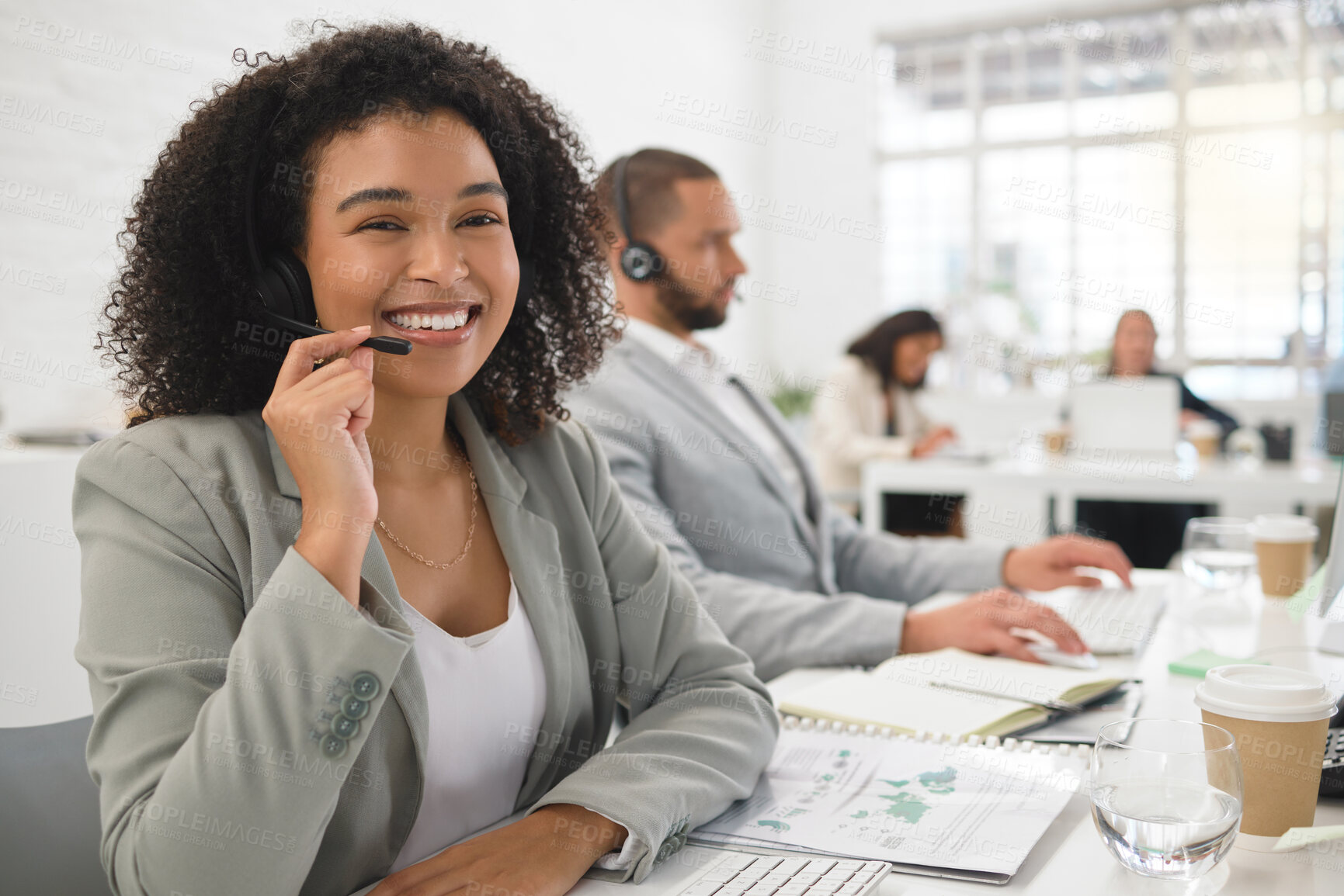 Buy stock photo Portrait of a young happy mixed race female call center agent answering calls while wearing a headset at work. One hispanic businesswoman with a curly afro talking on a call at a desk in an office