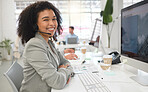 Portrait of a young happy mixed race female call center agent answering calls while wearing a headset at work. One hispanic businesswoman with a curly afro talking on a call while using a desktop computer at a desk in an office