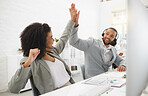 Two young happy mixed race call center agents giving each other a high five while answering calls in an office at work. Joyful hispanic customer service workers joining hands in motivation and support while working together