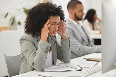 Buy stock photo Young mixed race businesswoman suffering from a headache while working on a desktop computer in an office at work. One stressed hispanic businessperson with a curly afro suffering from anxiety and looking upset