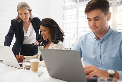Buy stock photo Three diverse businesspeople working together In an office at work. Mature businesswoman helping her colleagues with work on a computer. Young african american businesswoman using a laptop while getting help from a manager