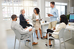 Group of five diverse businesspeople having a meeting in an office at work. Mature caucasian businesswoman explaining an idea to colleagues in a workshop. Business professionals planning together