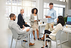 Group of five diverse businesspeople having a meeting in an office at work. Cheerful coworkers laughing together in a workshop. Business professionals planning together
