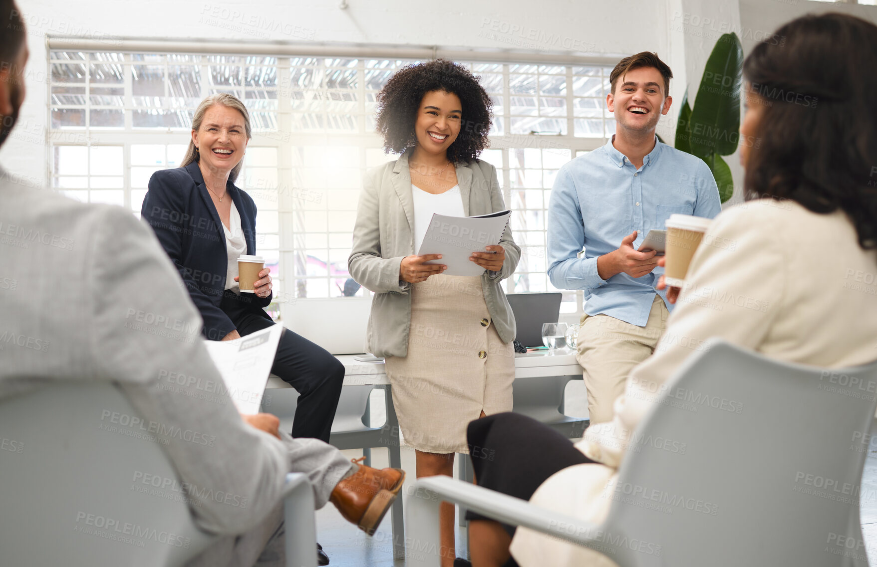 Buy stock photo Group of five diverse businesspeople having a meeting in an office at work. Cheerful coworkers laughing together in a workshop. Business professionals planning and going through a report