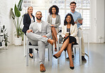 Portrait of a group of five cheerful diverse businesspeople sitting together at work. Business professionals having a meeting in an office. Colleagues planning together