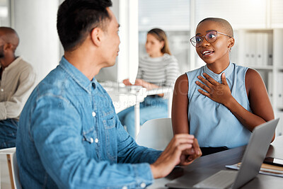 Buy stock photo Two businesspeople having a meeting together in an office at work. Young african american businesswoman talking to an asian businessman. Coworkers planning and using a laptop at work