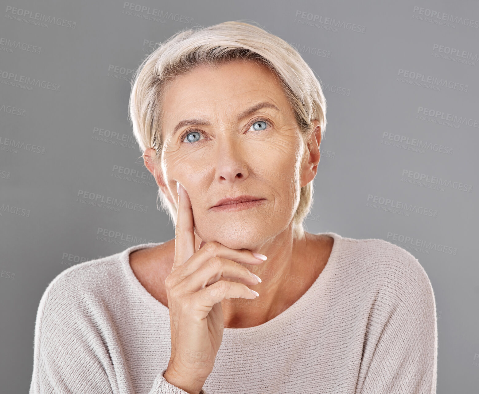 Buy stock photo Mature, thinking and woman touching her face in isolated grey studio background. Copy space for anti ageing skincare  or cosmetic products for senior feeling her skin and wrinkles headshot. 