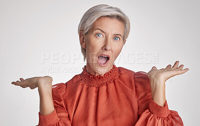 Buy stock photo Mature surprised, wow and shocked woman face against a grey copy space grey studio background posing with her hands up and feeling unsure. Portrait of senior model making facial expression or emotion