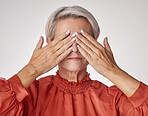 One mature woman suffering with a headache and looking stressed while posing against a grey copyspace background. Ageing woman experiencing anxiety and frustration in a studio