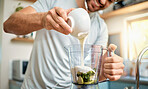 Closeup of one caucasian man pouring yoghurt into blender for healthy green detox smoothie in kitchen at home. Guy having fresh fruit juice to cleanse and provide energy for training. Wholesome drink with vitamins and nutrients